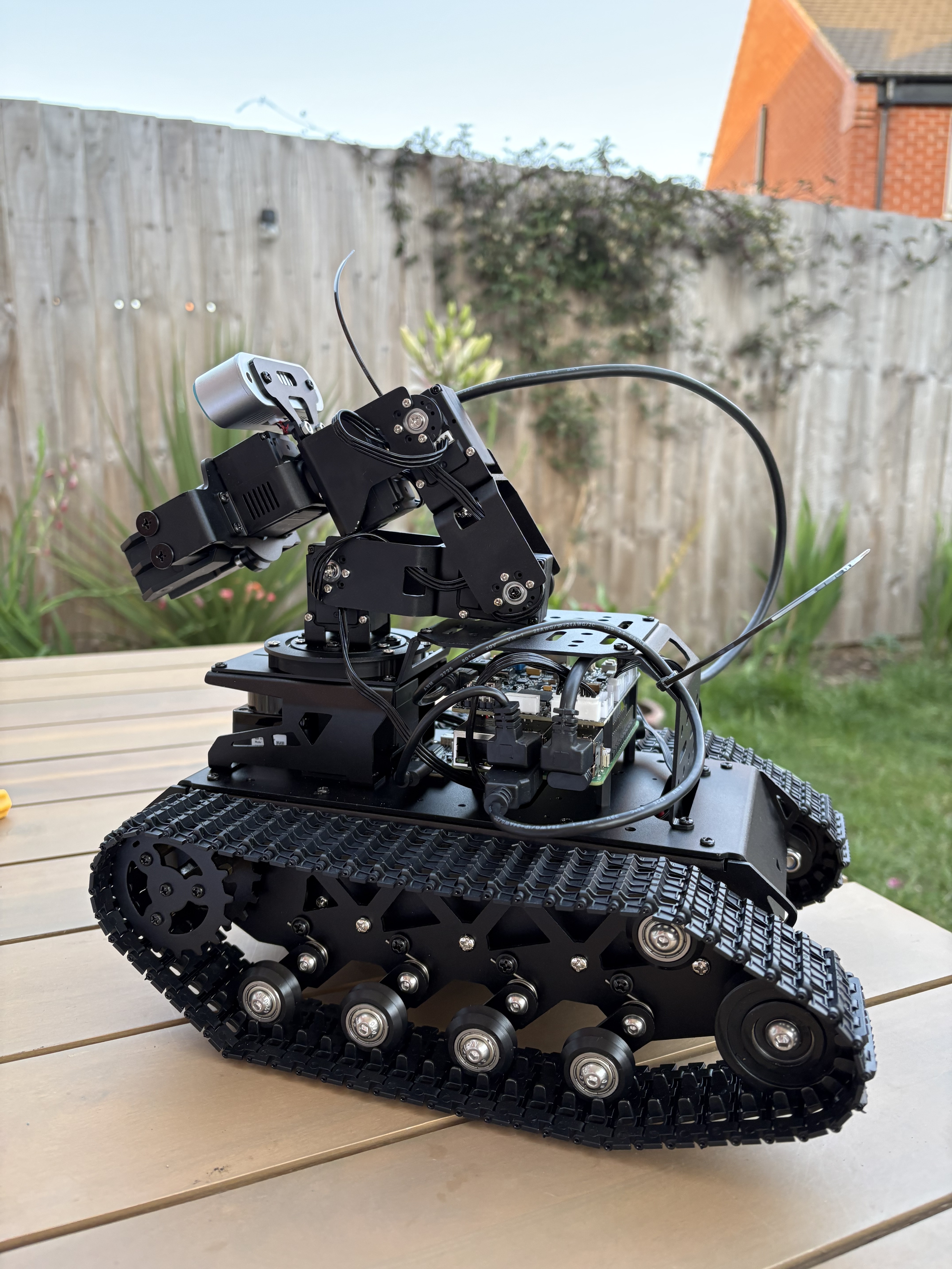 The assembled Tyina tracked robot with an arm, depth camera, and Raspberry Pi.